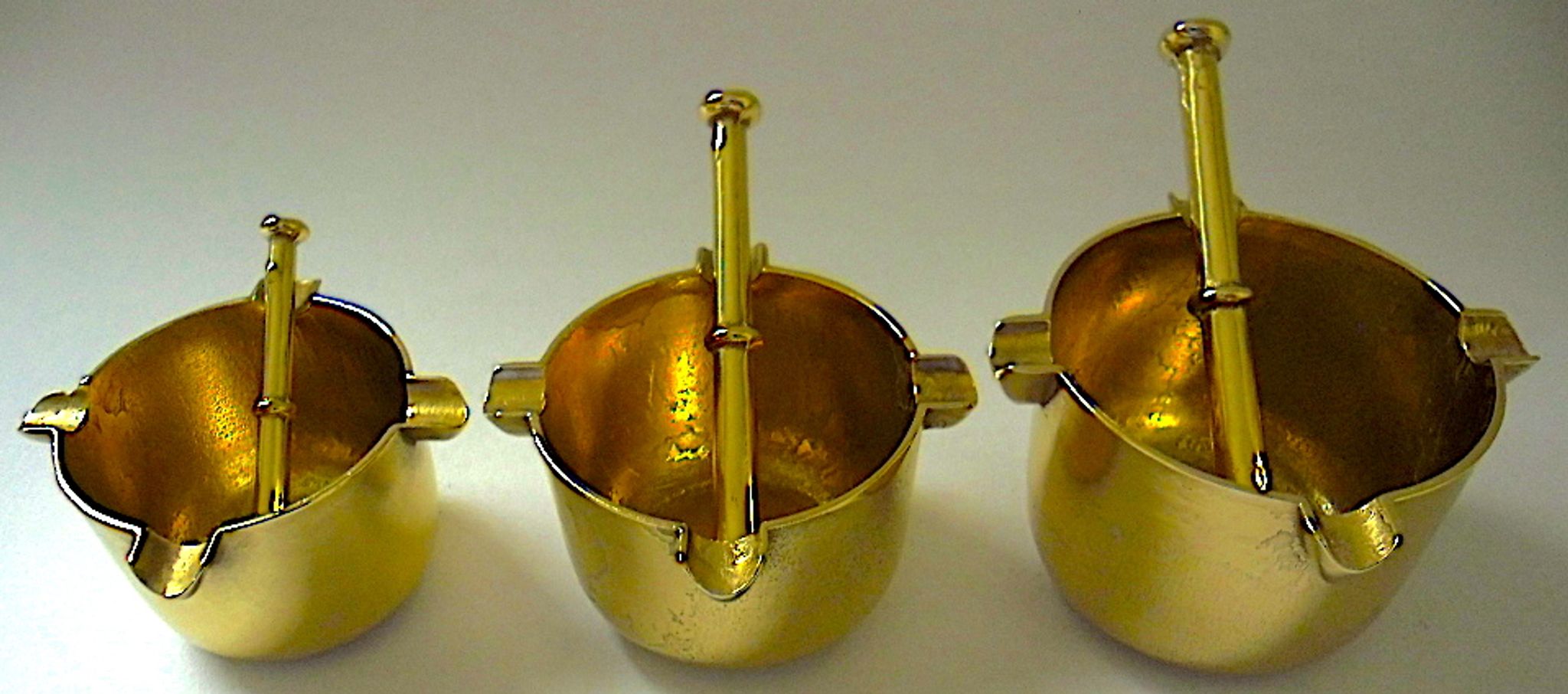 Three "vintage" bronze ashtrays with golden natural patina forming mortars with their drumsticks