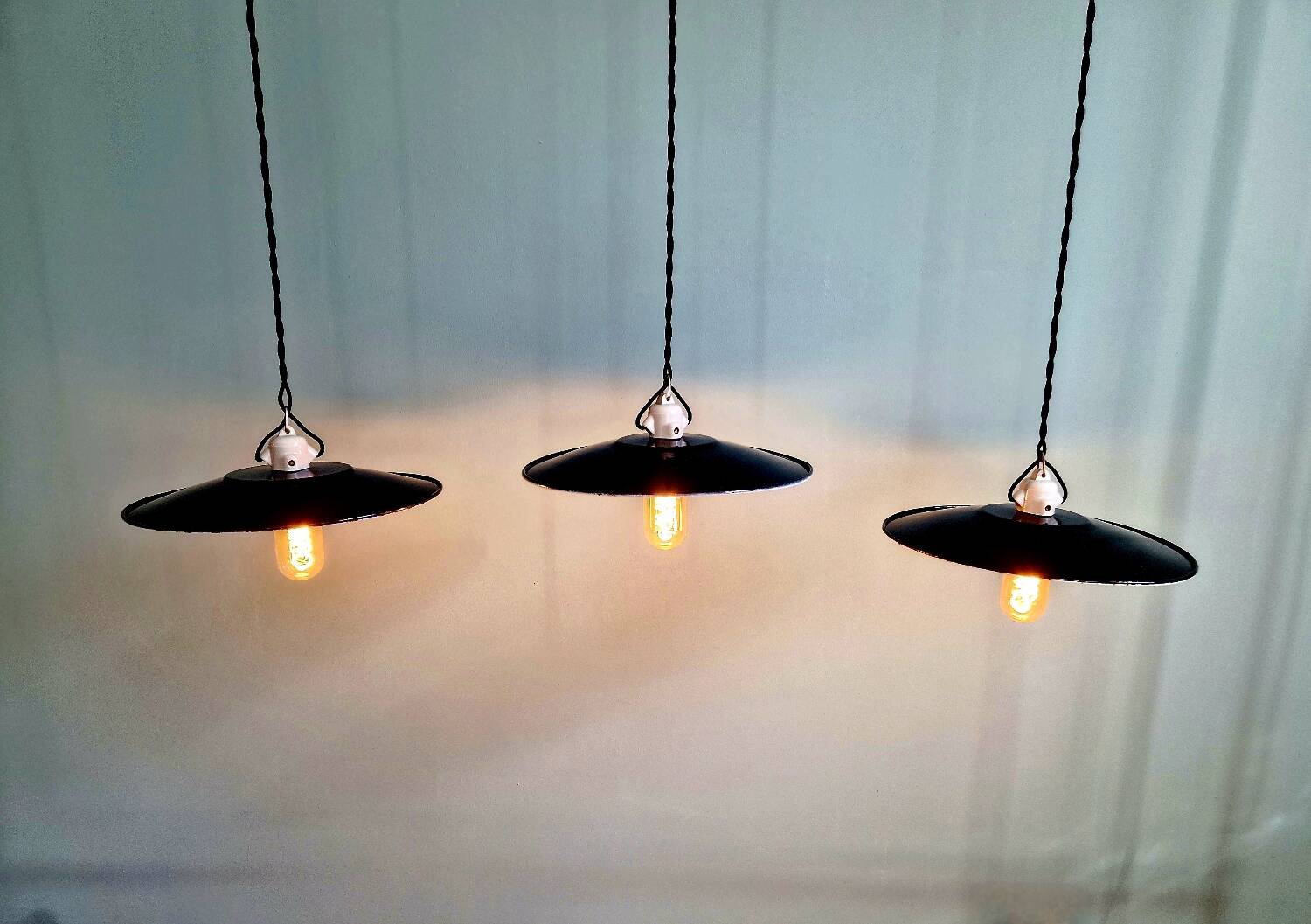 Three industrial suspensions in black enamelled sheet metal.