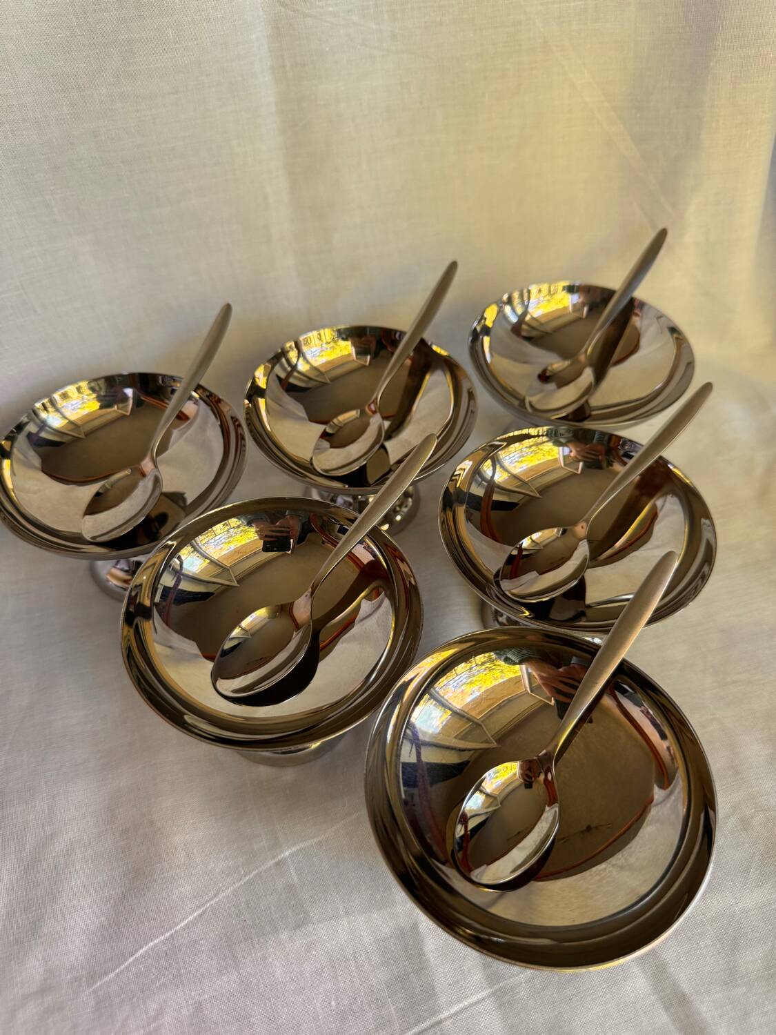 Set of 6 stainless steel ice cream bowls by Guy Degrenne with matching spoons.