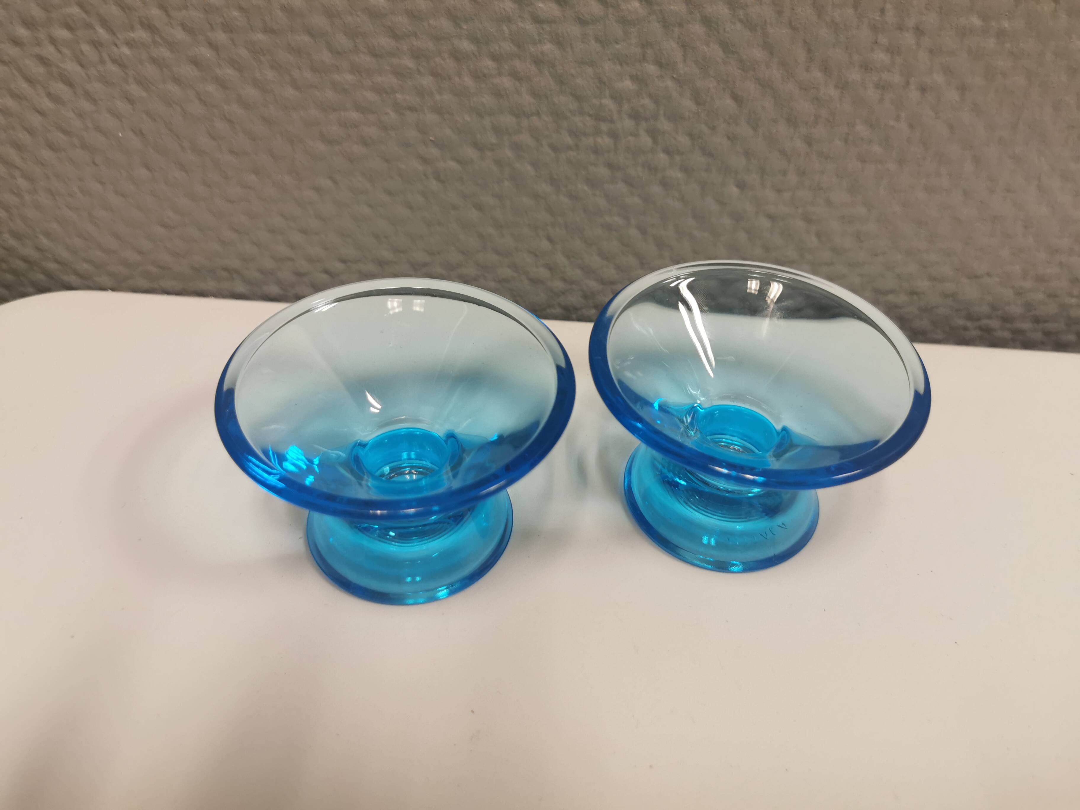 Two small candle holders in blue glass from the well-known Finnish company Ittala.