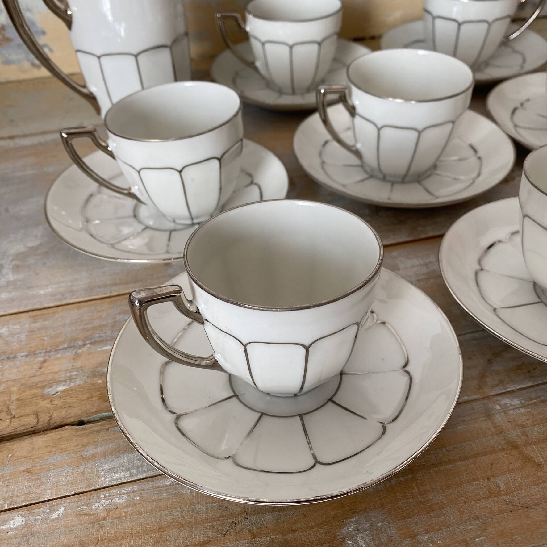 White and silver Limoges porcelain coffee cups and saucers.