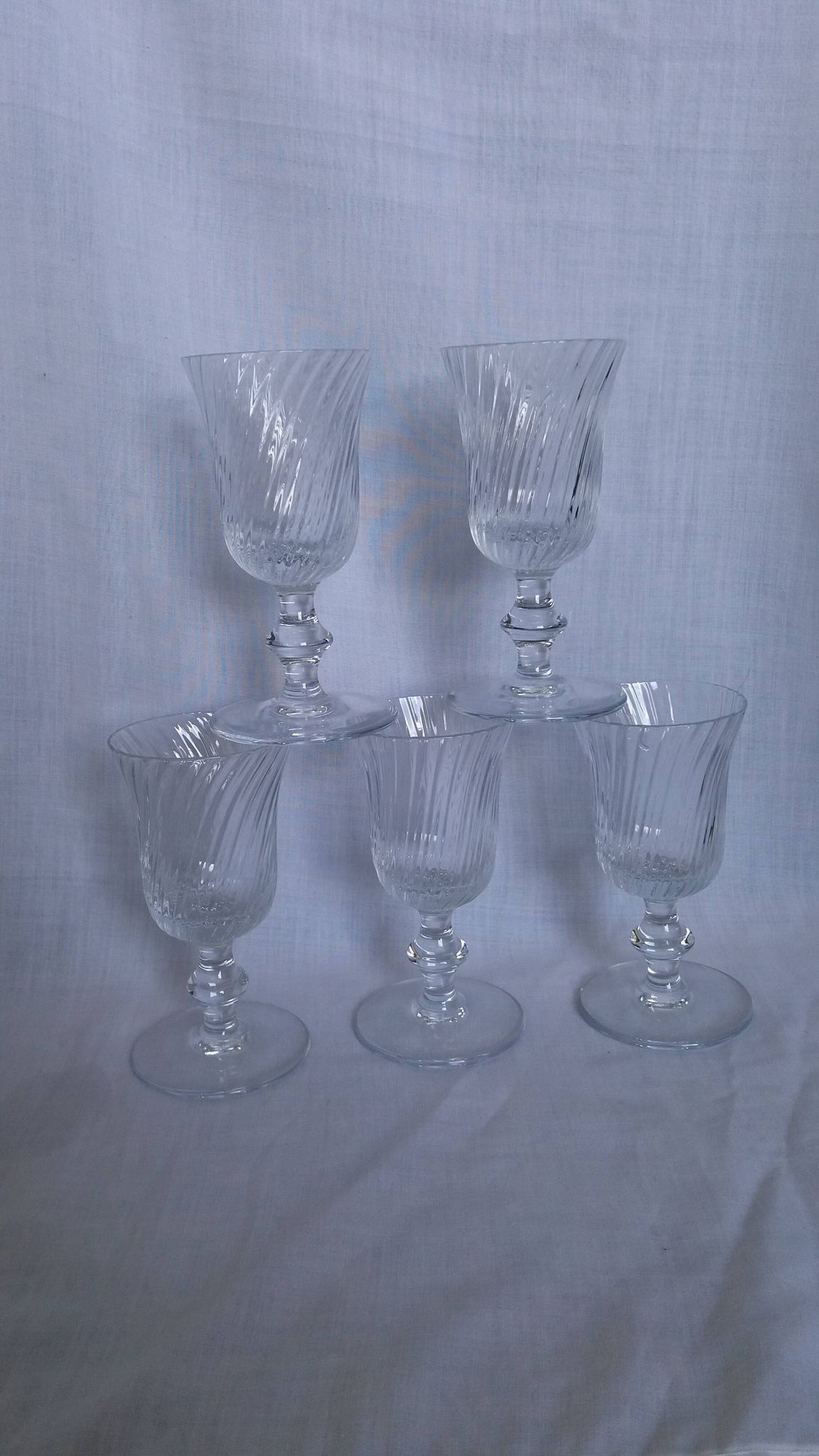 Ancient footed crystal glasses with relief twisted fluted goblets.