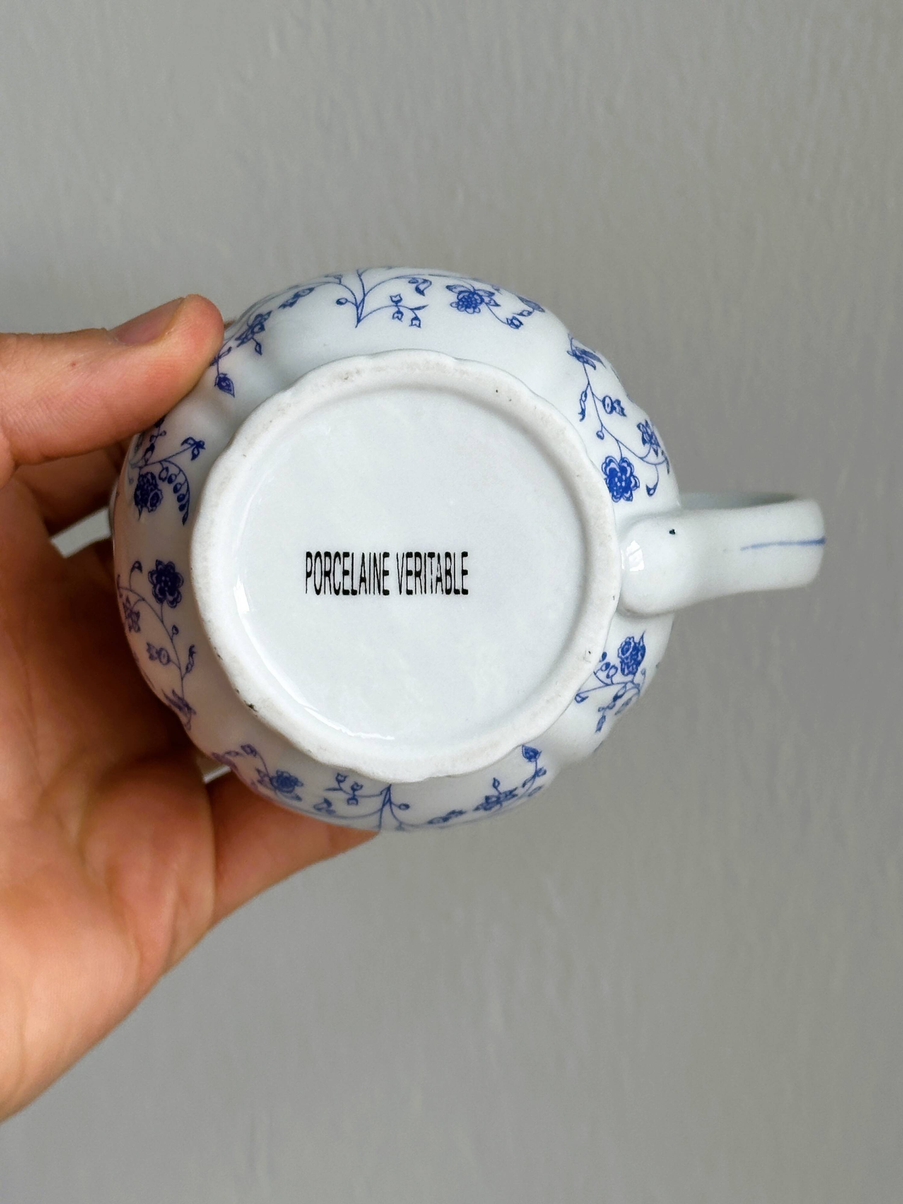 White porcelain milk jug with blue floral designs.
