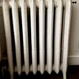 Radiateur ancien sur pieds à huit lames fleuries en fonte de fer XX siècle