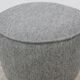 Modern pouf from the Gubi brand in grey fabric and brass.