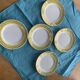 6 small plates with yellow borders and floral pattern gold antiques
