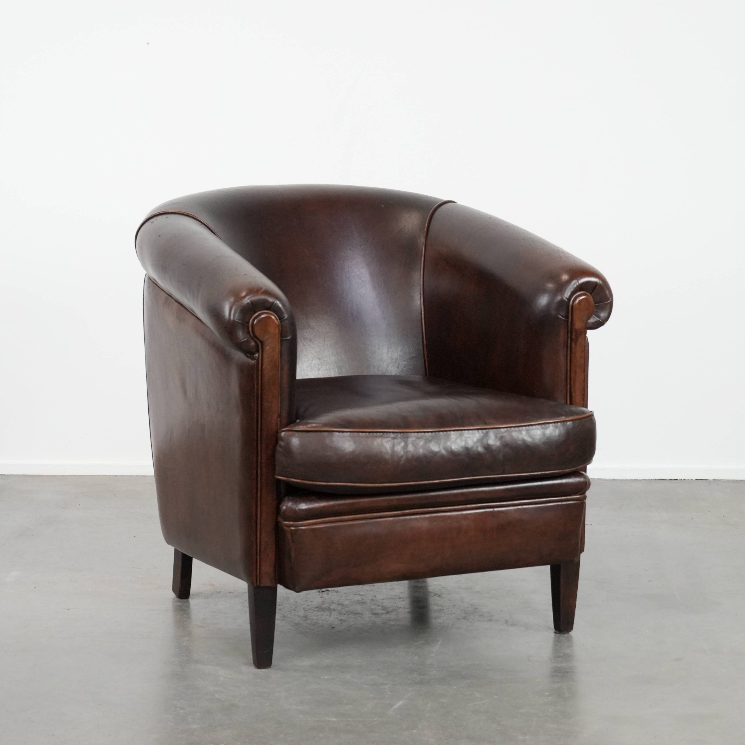Dark brown vintage club armchair in English style made of sheepskin leather