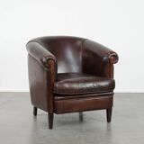 Dark brown vintage club armchair in English style made of sheepskin leather