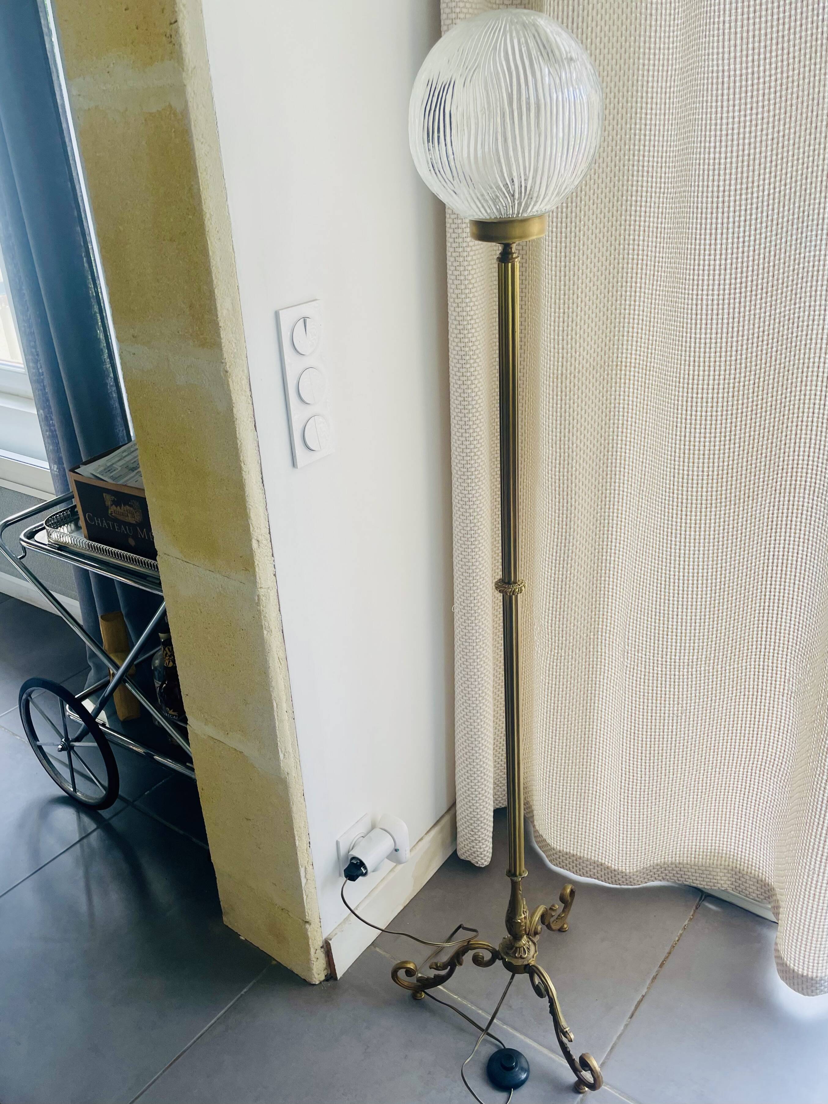 Floor lamp in gilded brass and round glass globe