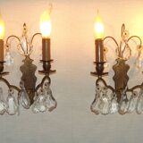 Pair of French antique brass double wall lights with assorted crystals.