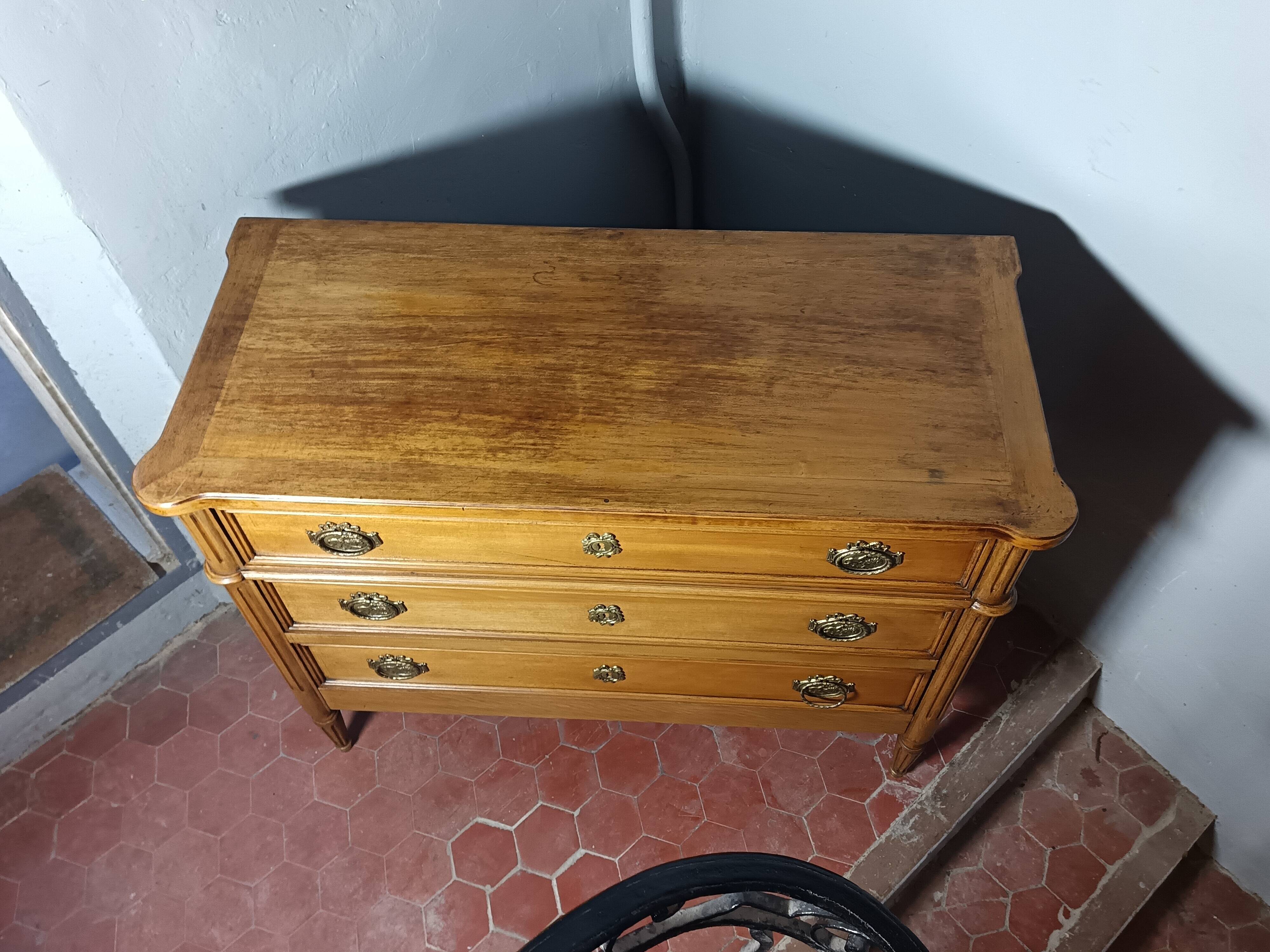 Commode de style Louis XVI ouvrant à trois tiroirs.