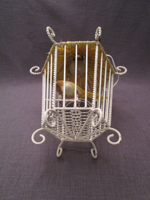 Vintage suspension cage has metal birds and raffia