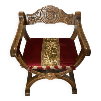 Fauteuil Dagobert néogothique en bois sculpté – Armoiries et velours rouge