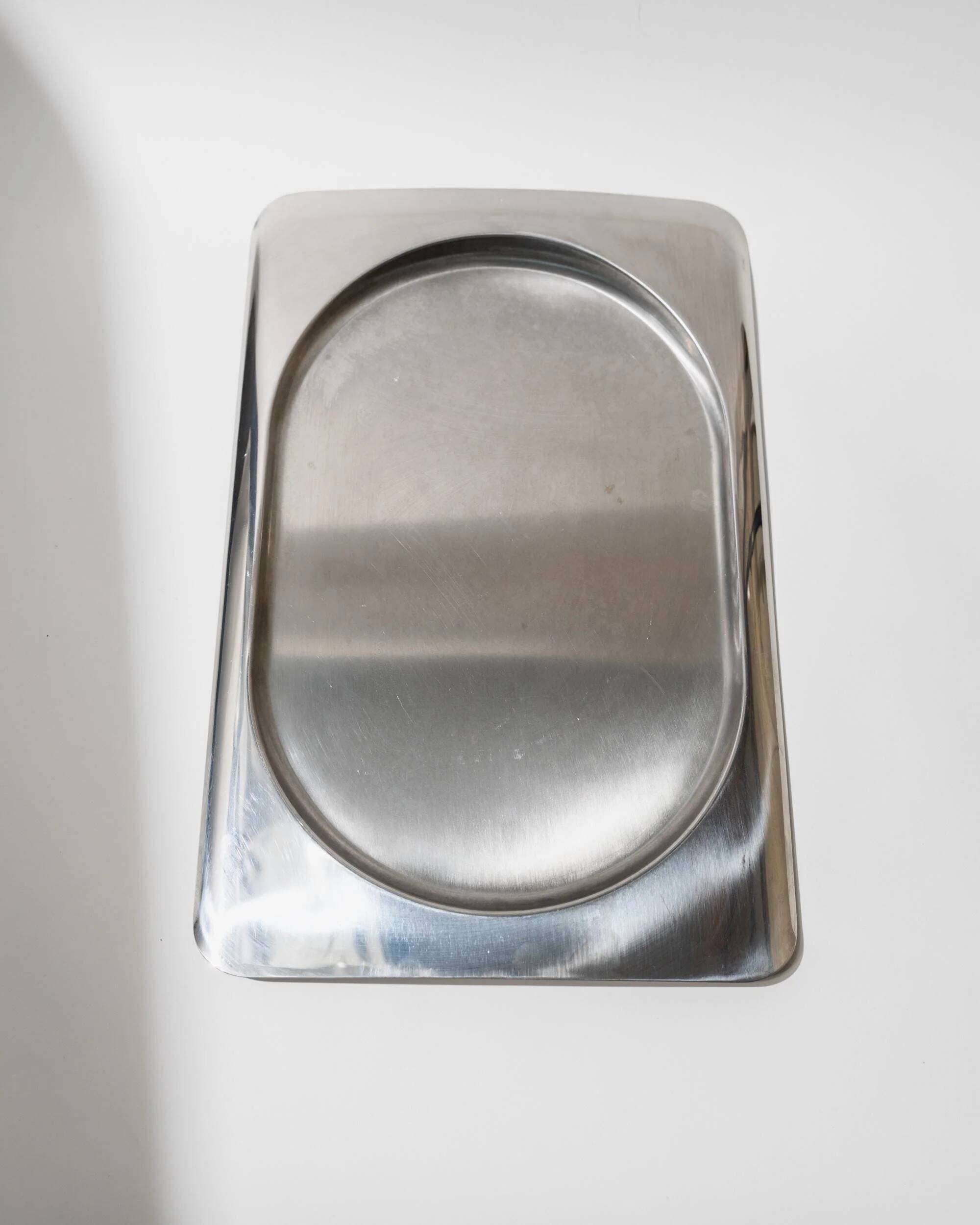 1990s vintage stainless steel platter, rectangular with an oval indentation, minimalist modern design.