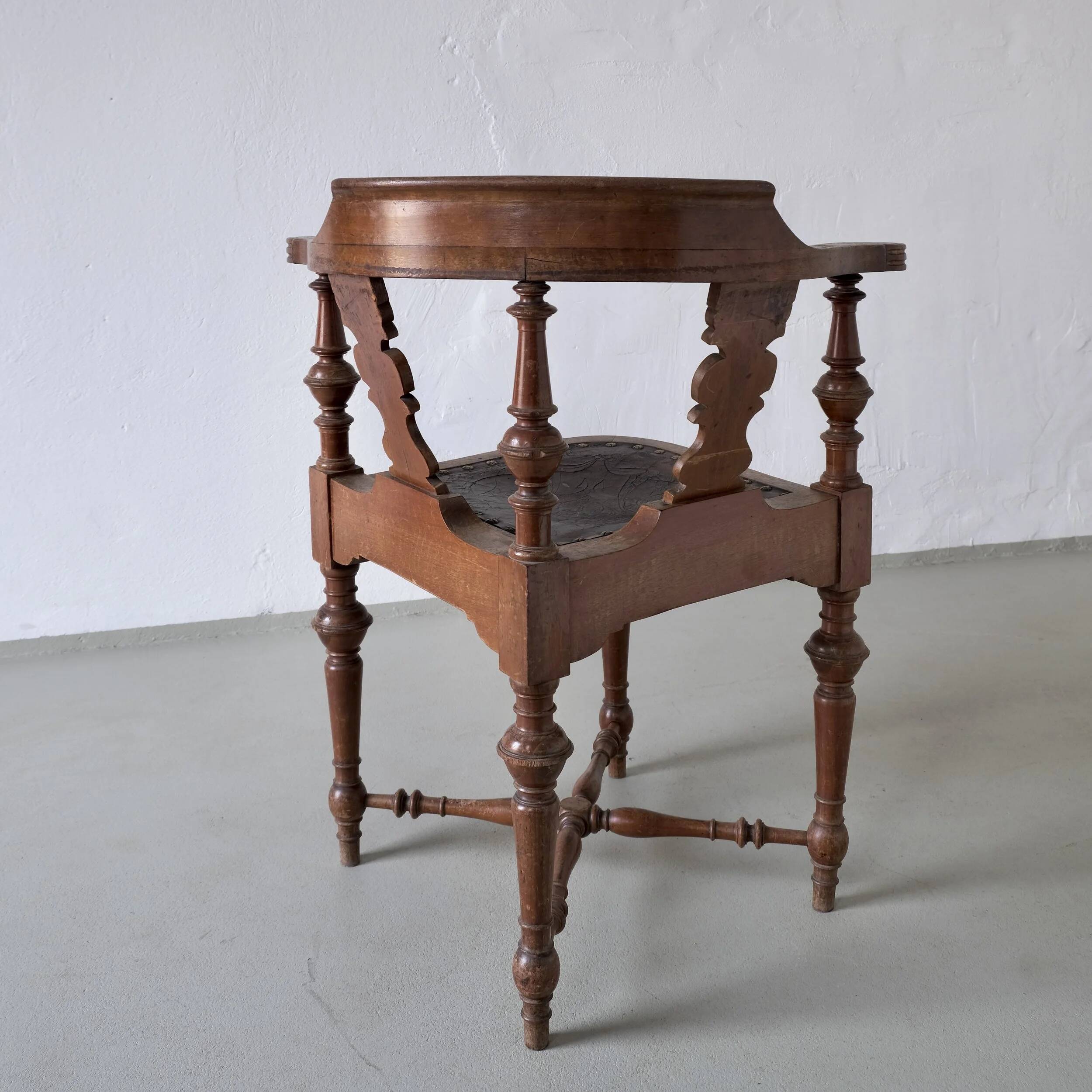 Fauteuil d'angle ancien sculpté avec assise en cuir