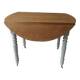 Walnut table with raised flaps, base on verdigris casters.