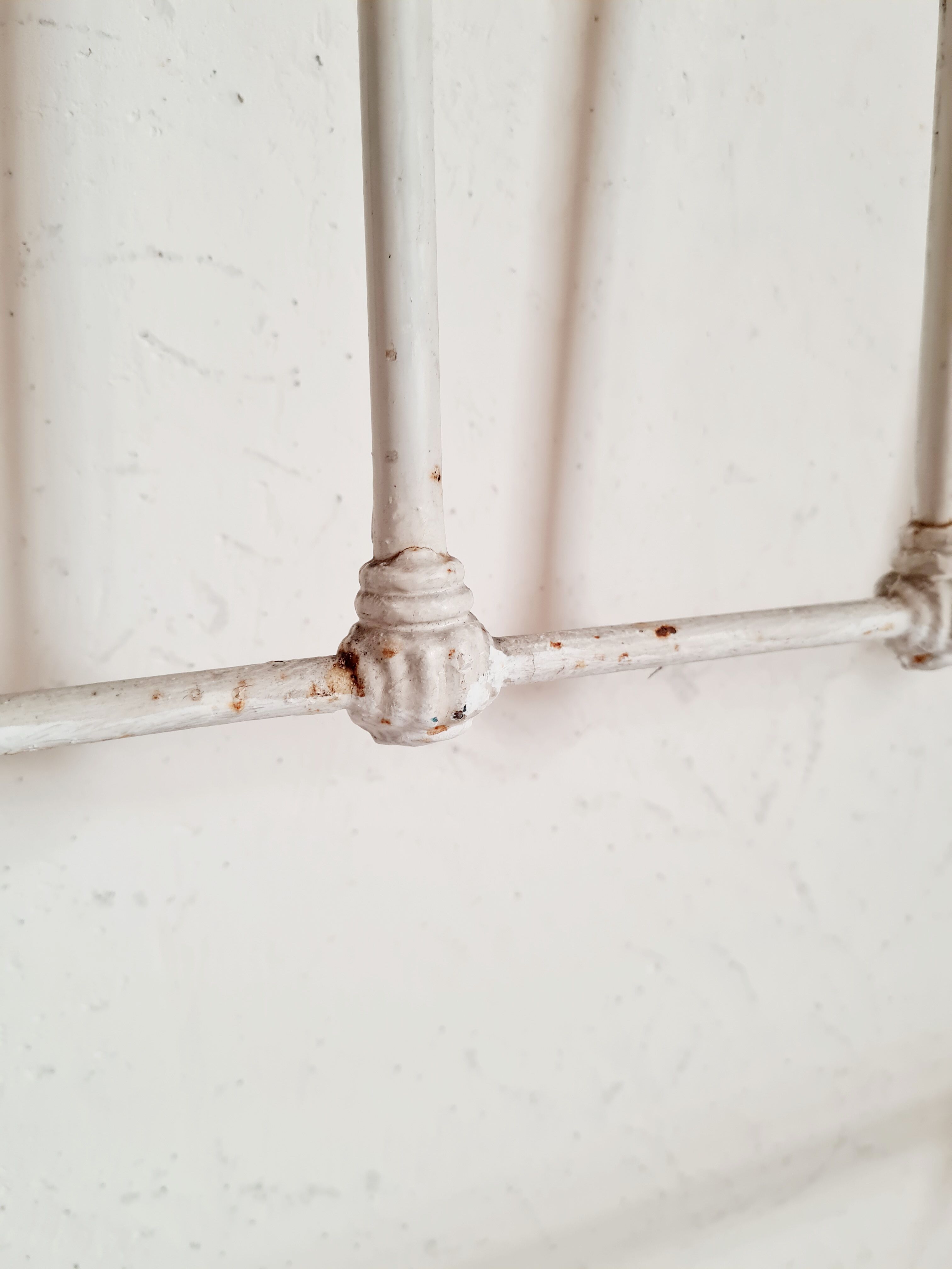 Cast-iron headboard and patinated white wood