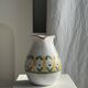Large white terracotta carafe with a stylized green and yellow frieze pattern