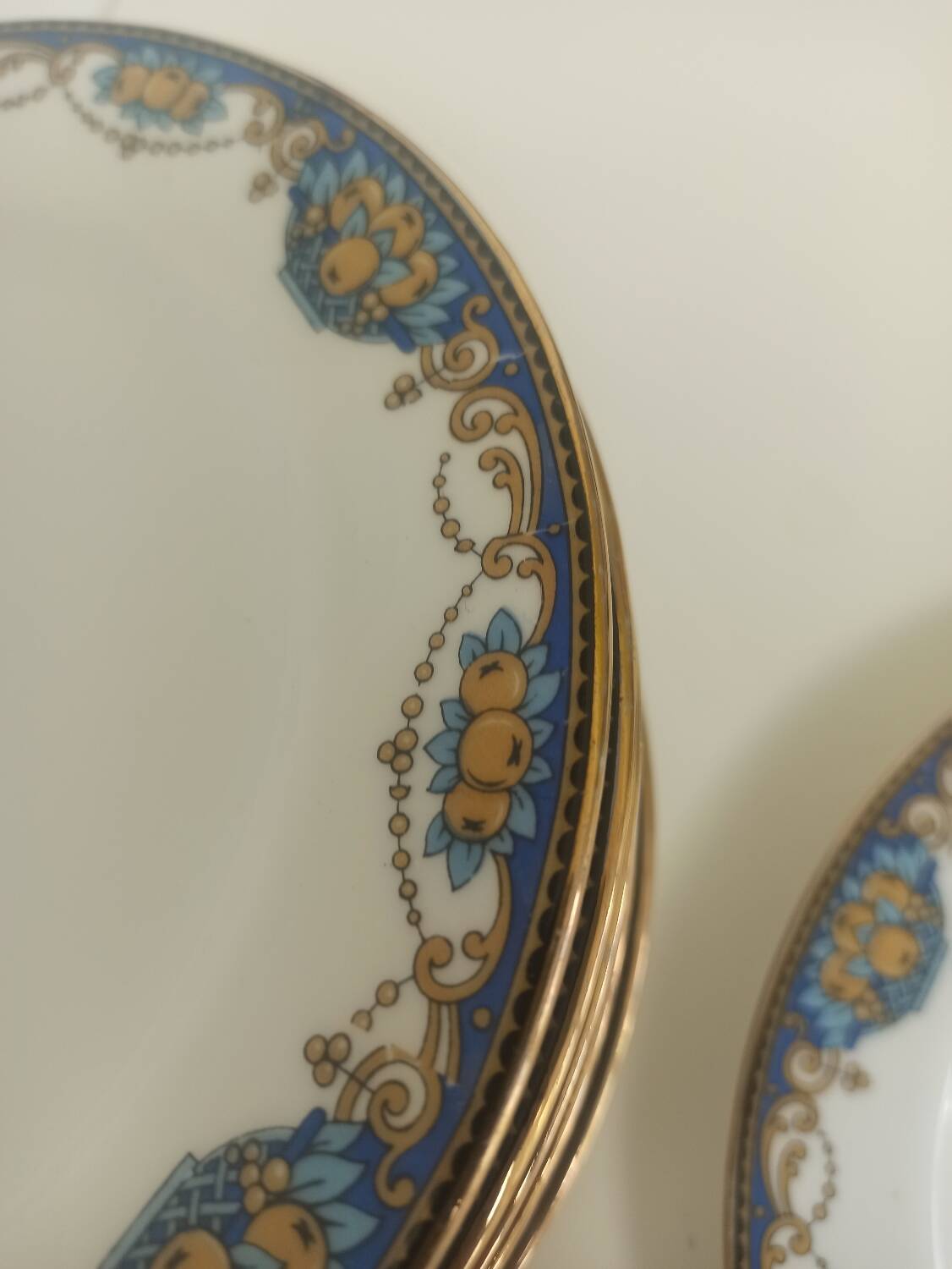 12 assiettes en porcelaine de Limoges à décor de guirlandes et de fruits