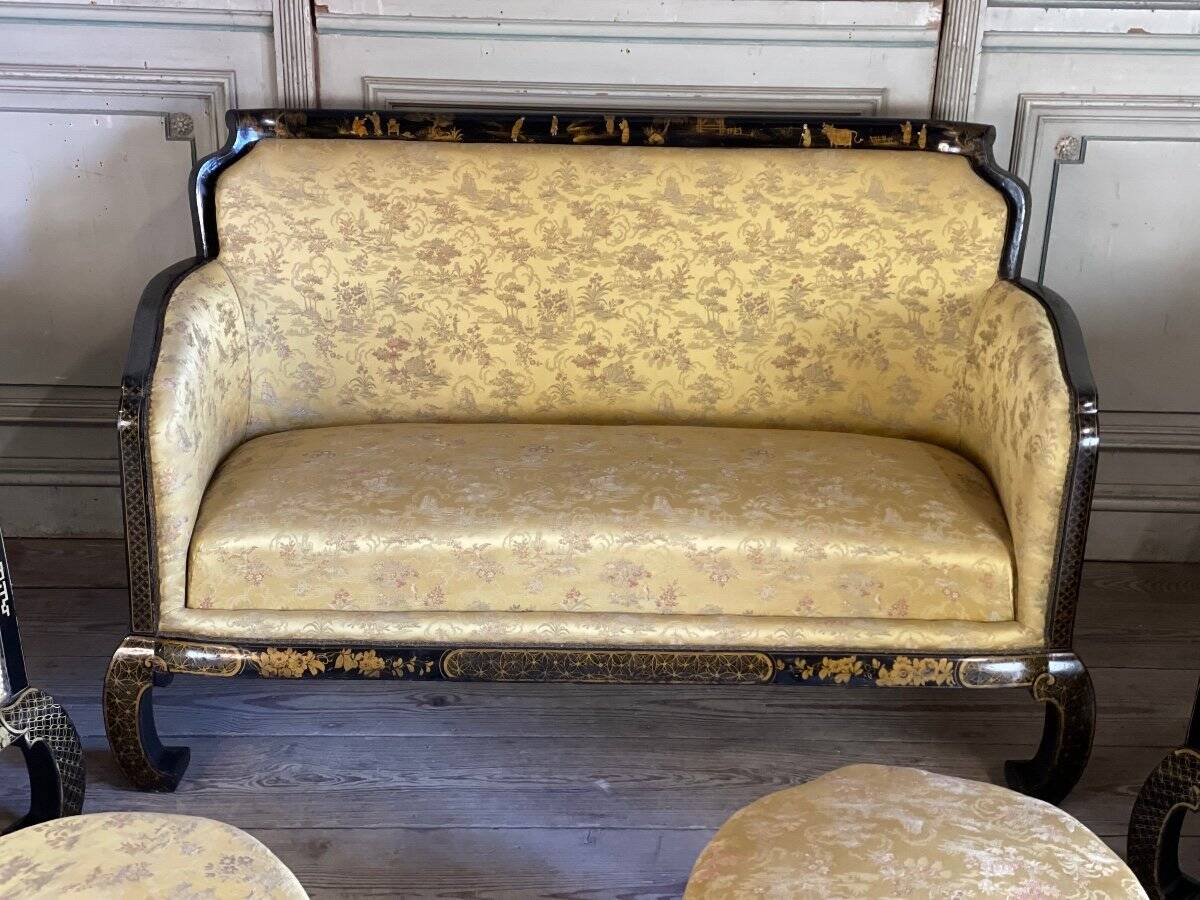 A set of two armchairs, a sofa and two poufs in lacquered wood with gilded chinoiserie decoration.