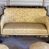 A set of two armchairs, a sofa and two poufs in lacquered wood with gilded chinoiserie decoration.