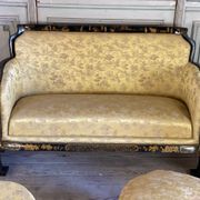 A set of two armchairs, a sofa and two poufs in lacquered wood with gilded chinoiserie decoration.