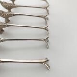 Six silver-plated knife rests in the shape of peacocks.