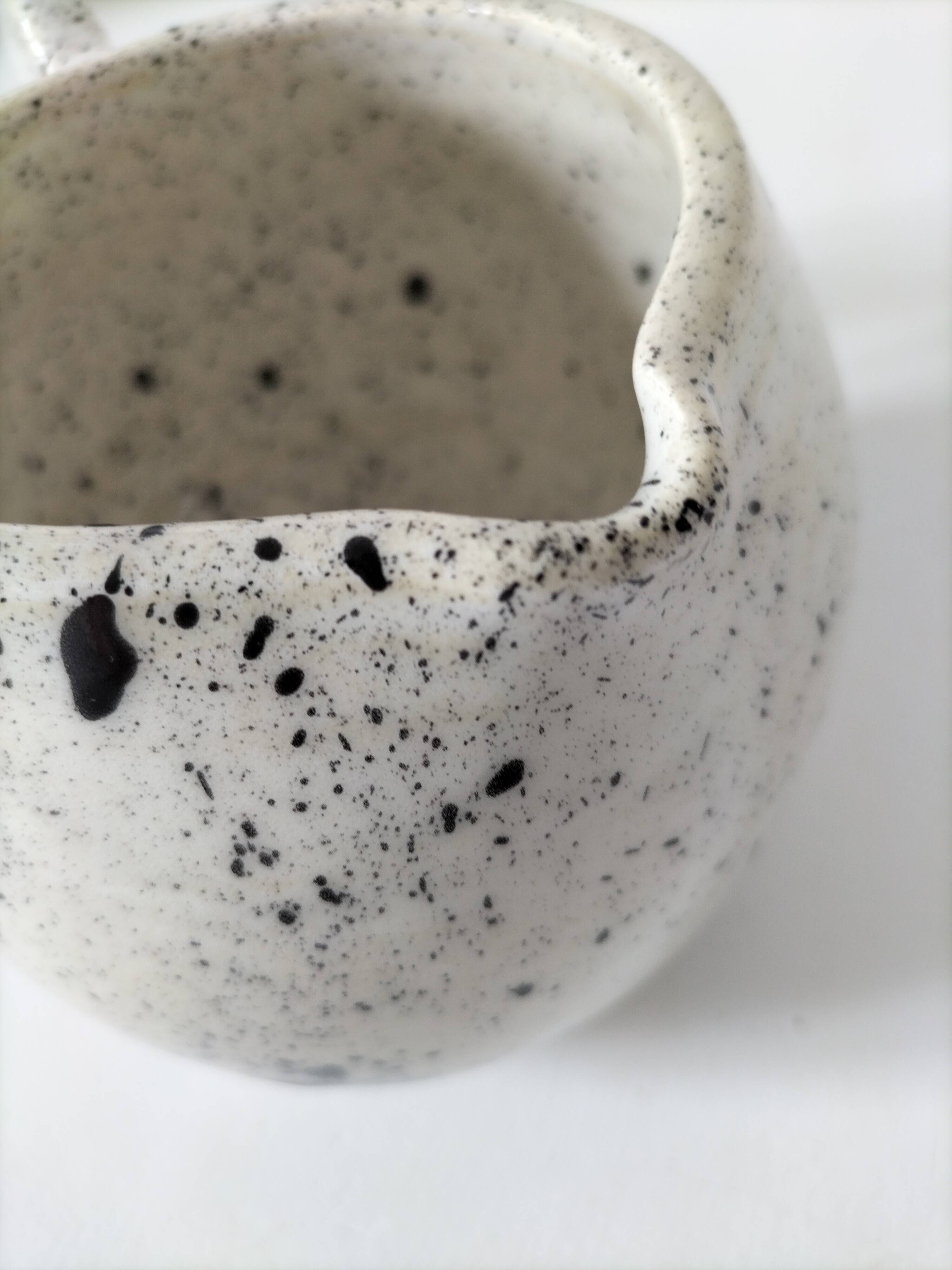 Small speckled ceramic jug in a vintage workshop style.