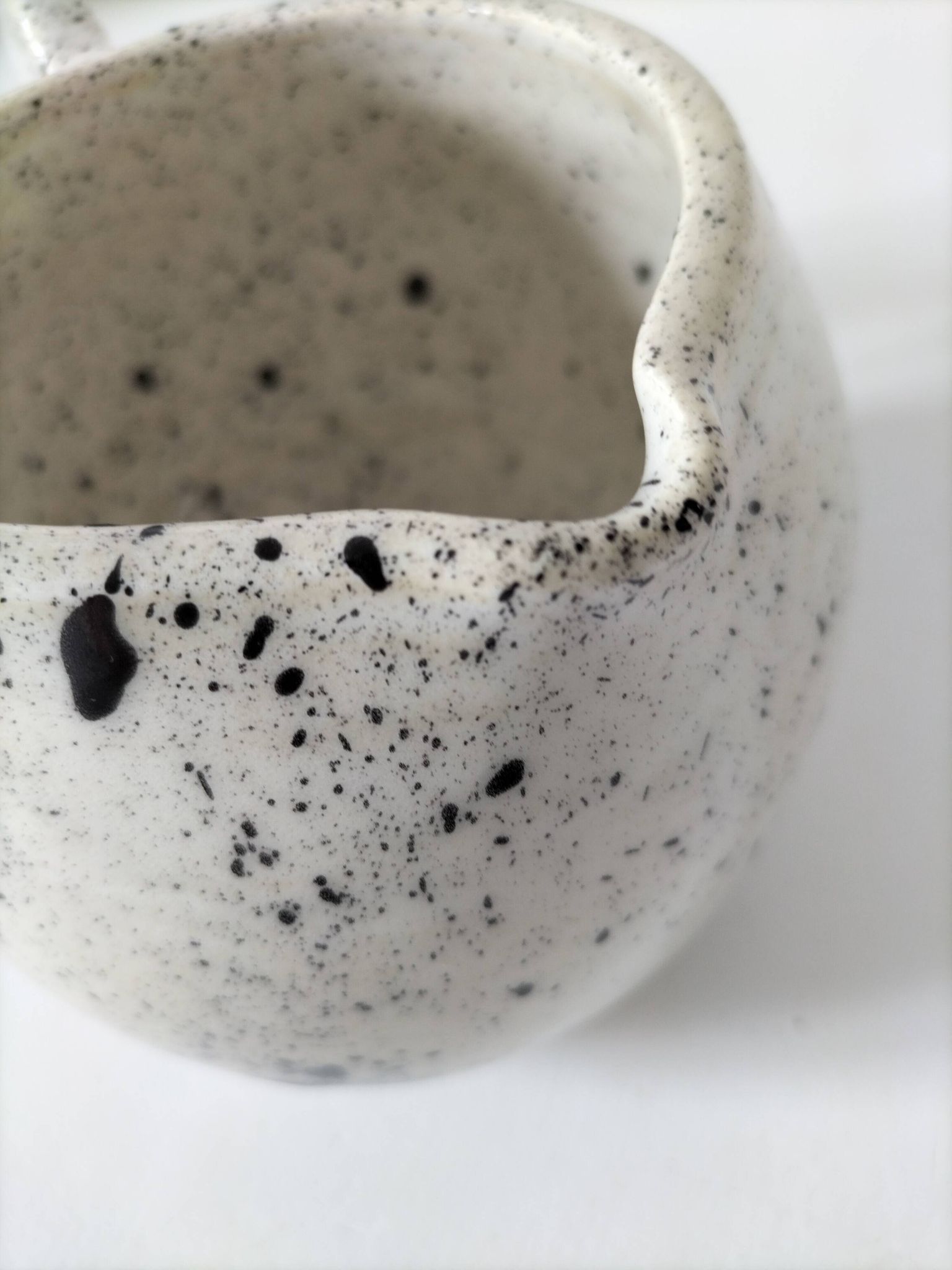 Small speckled ceramic jug in a vintage workshop style.