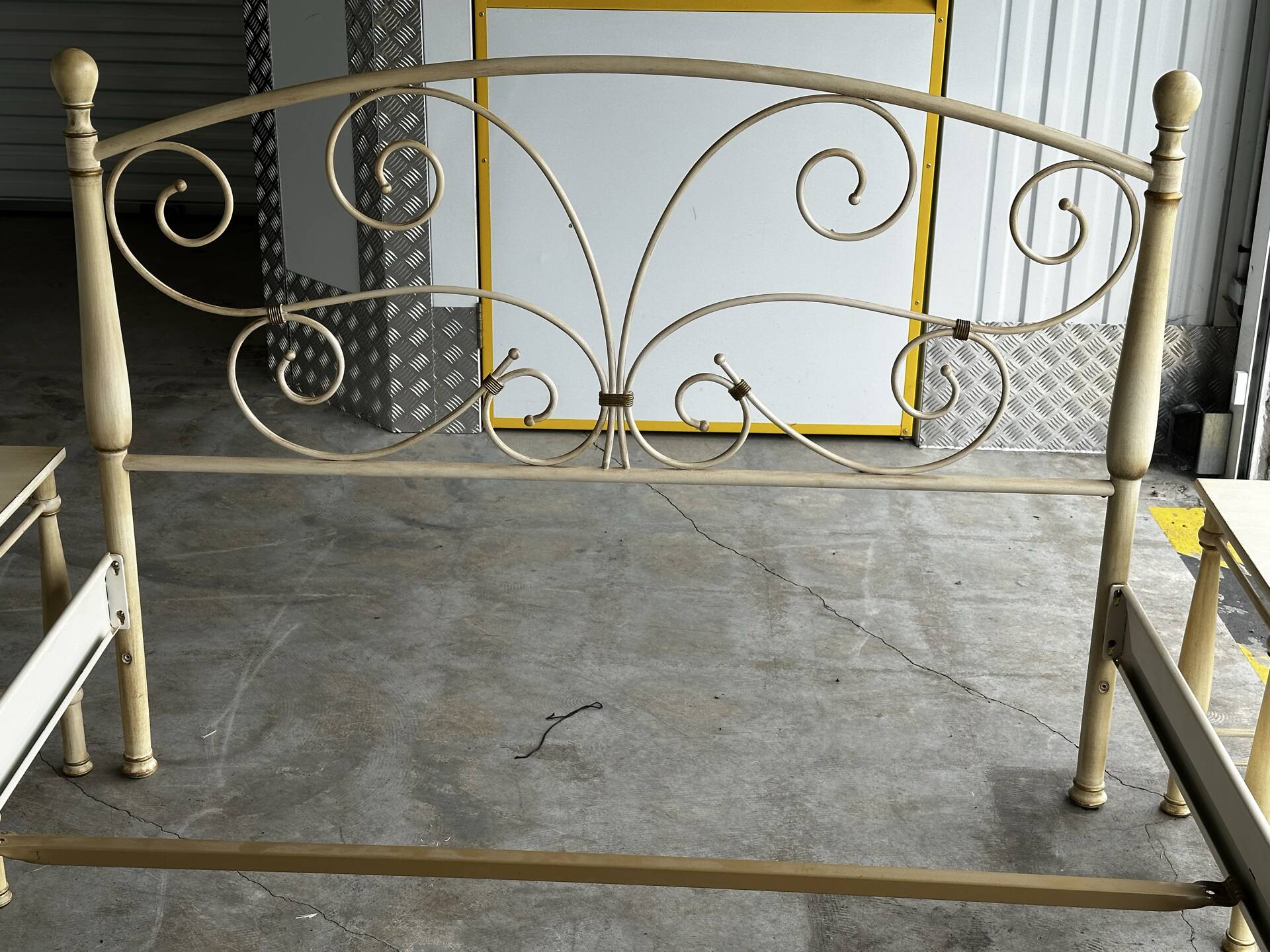 Patinated metal and wood double bed with integrated bedside tables.
