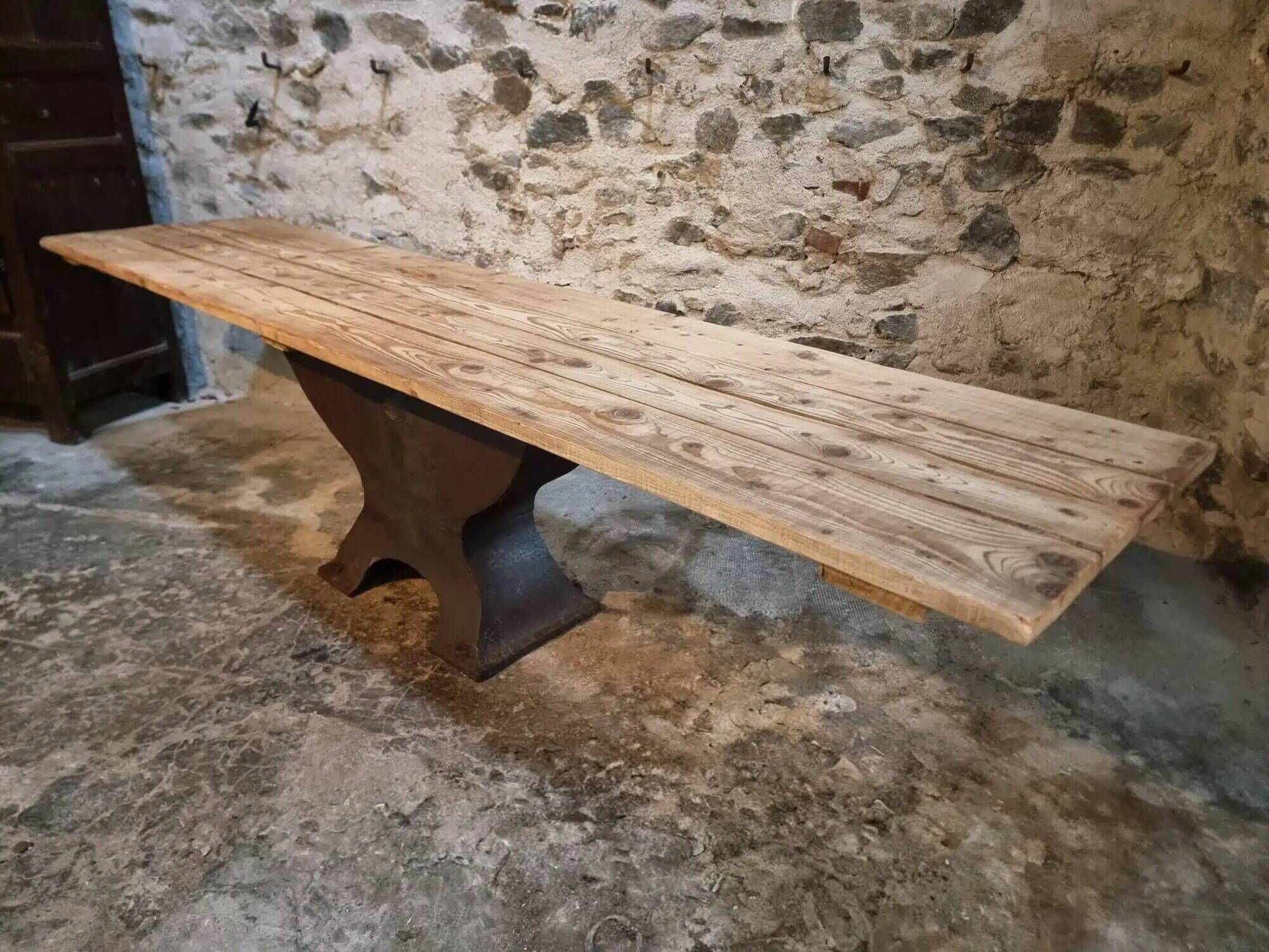 Old French industrial table with a cast iron base and a pine top.
