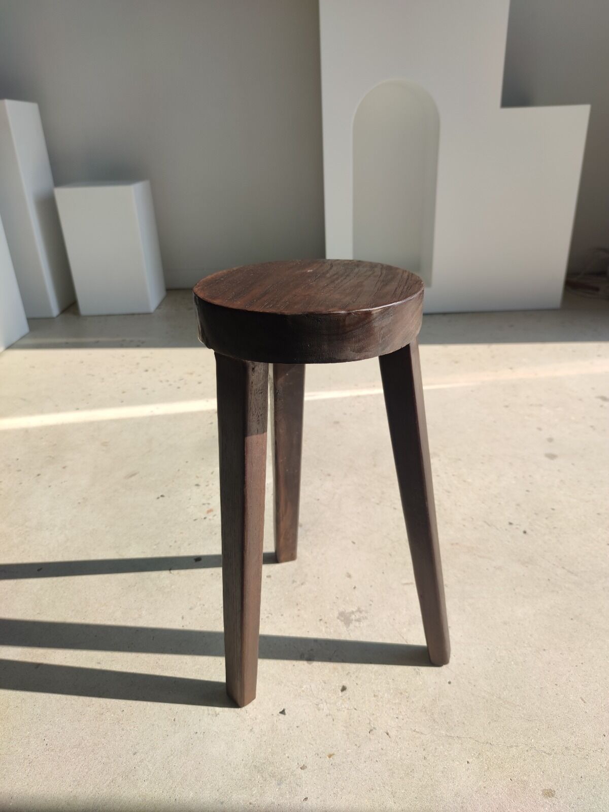 Small high tripod stool in brown solid wood