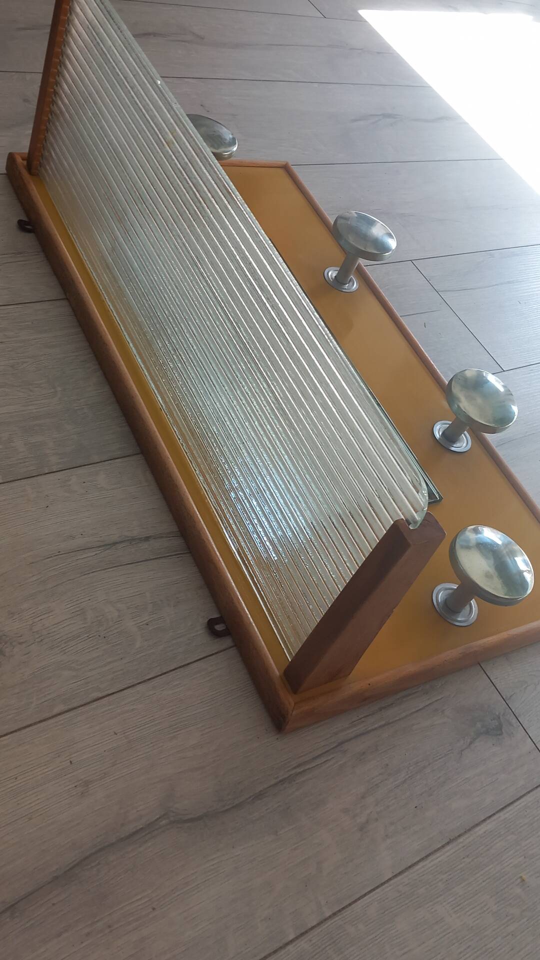 1950s coat rack with mirror, metal hooks, and glass shelf.