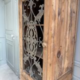 Column storage unit with a sculpted metal door.