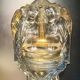 Old wall-mounted holy water font in moulded glass decorated with angels.
