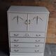 Mid-century wooden dresser painted in cream white, with 2 doors and 4 drawers, brass fittings.