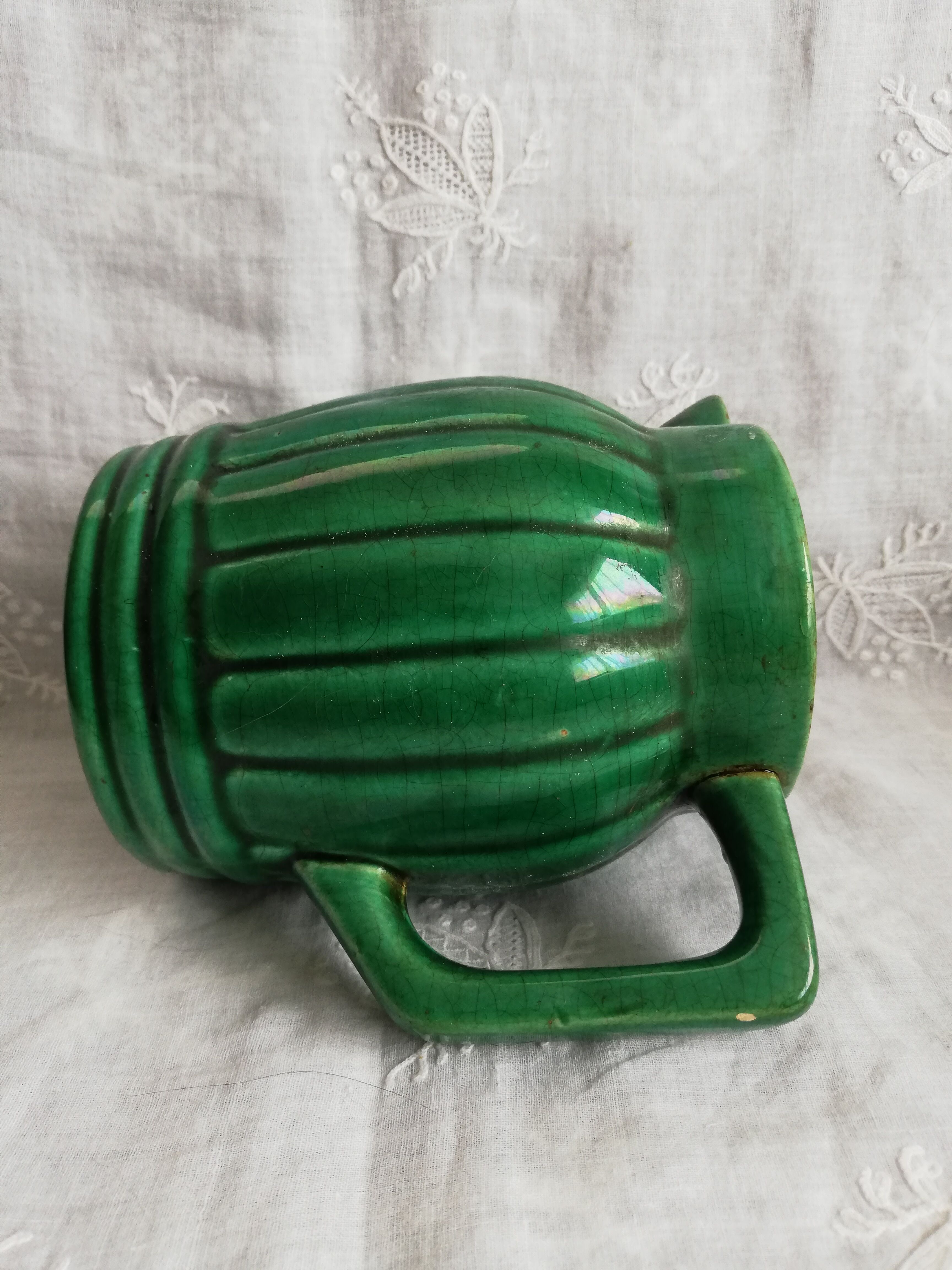 Old green pitcher in dabbling