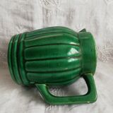 Old green pitcher in dabbling