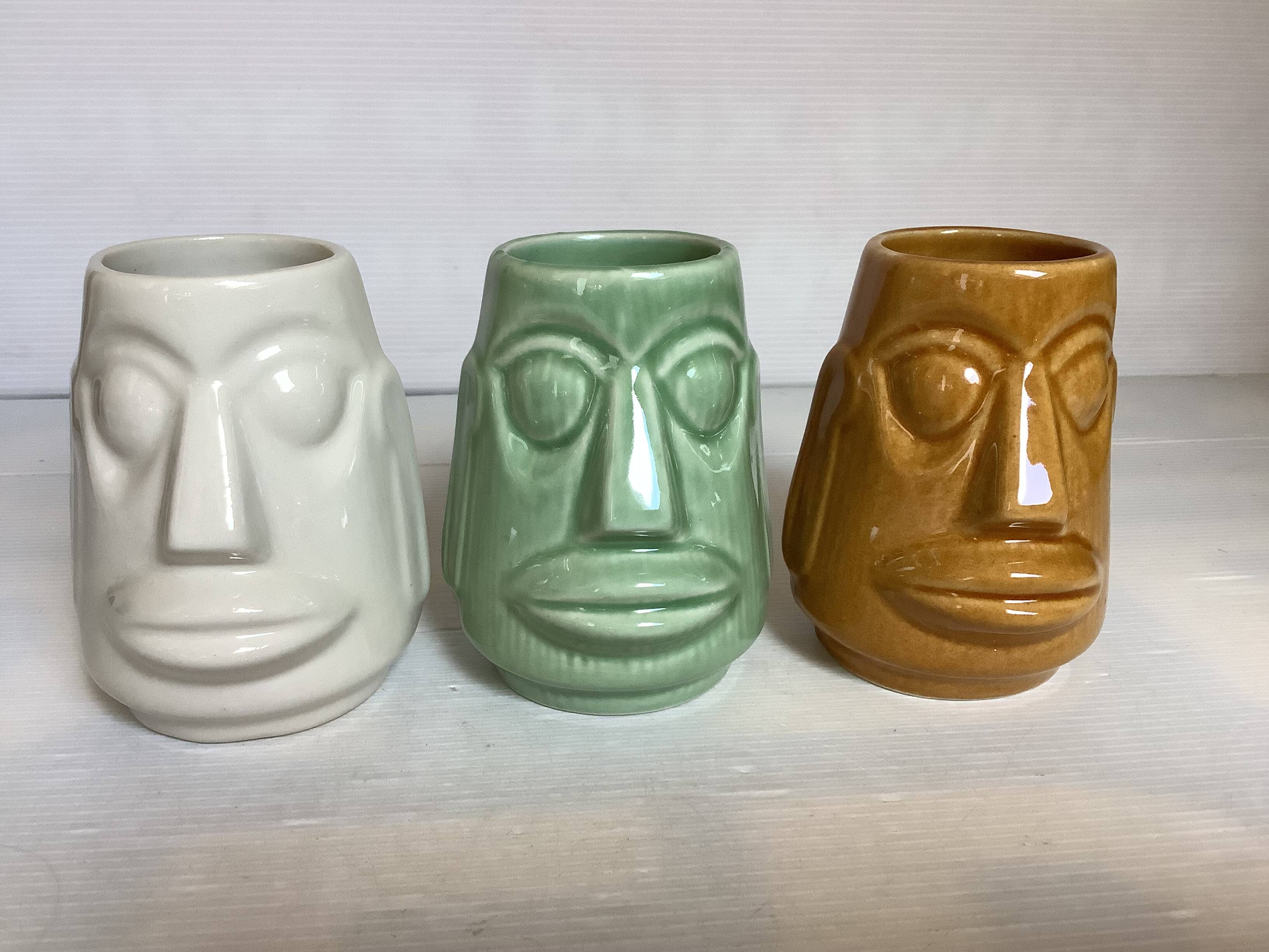 Set of three small Moai-style head vases.