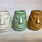 Set of three small Moai-style head vases.