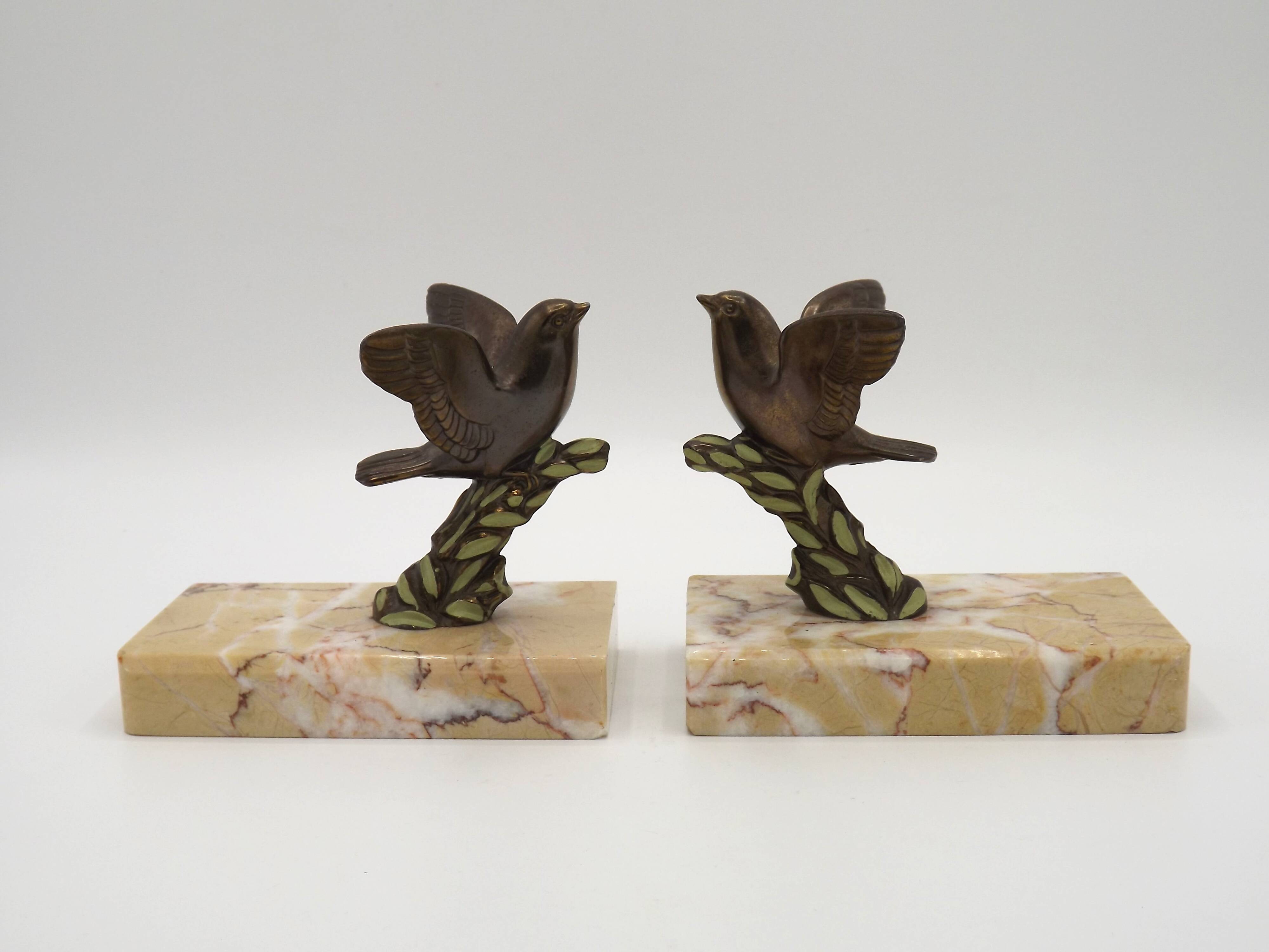 Paire de serre-livres Art déco français en étain représentant des oiseaux perchés sur une branche, socle en marbre