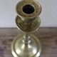Brass candle holder with flowers and round shape.