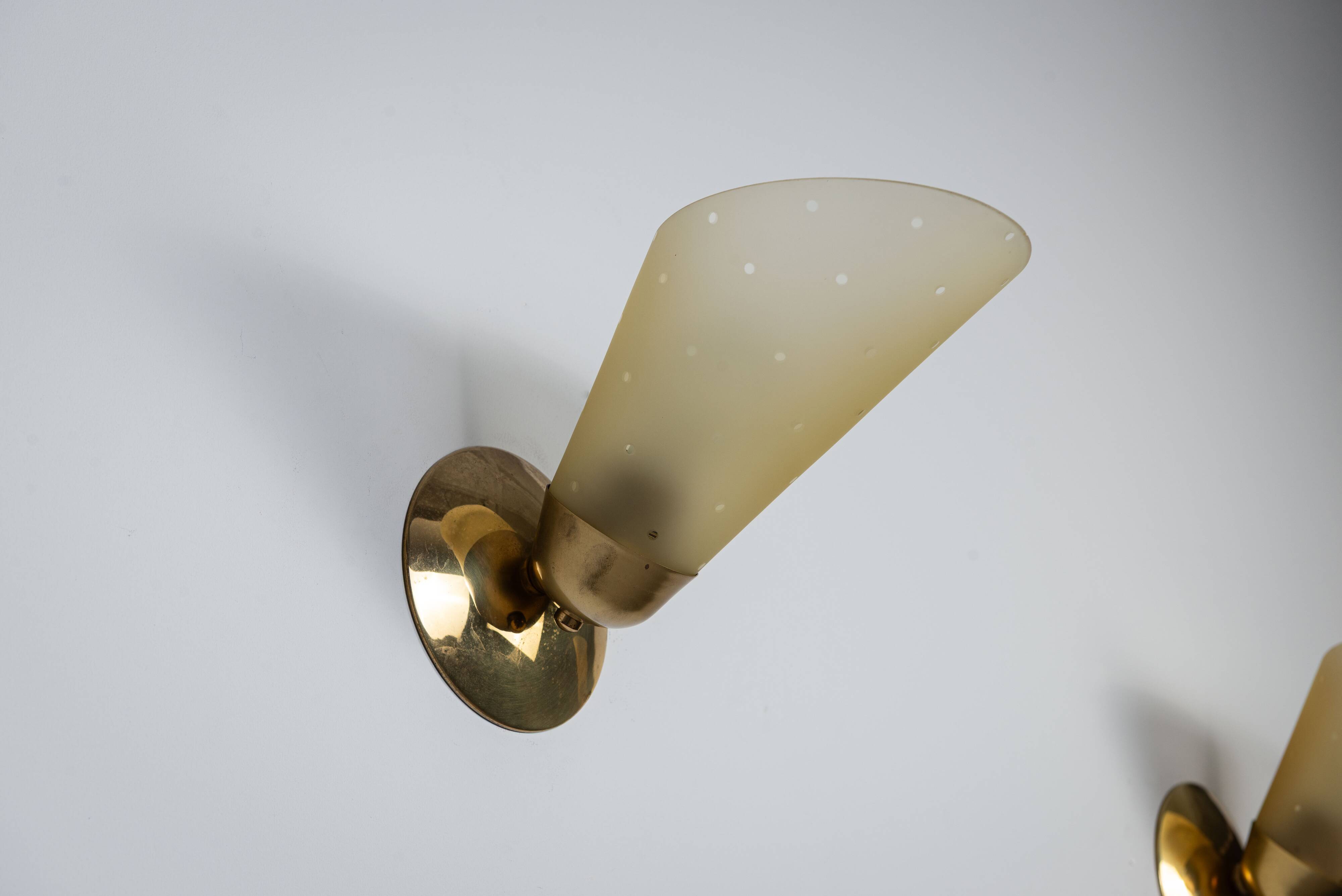 Set of three brass sconces with decorated yellow glass shades