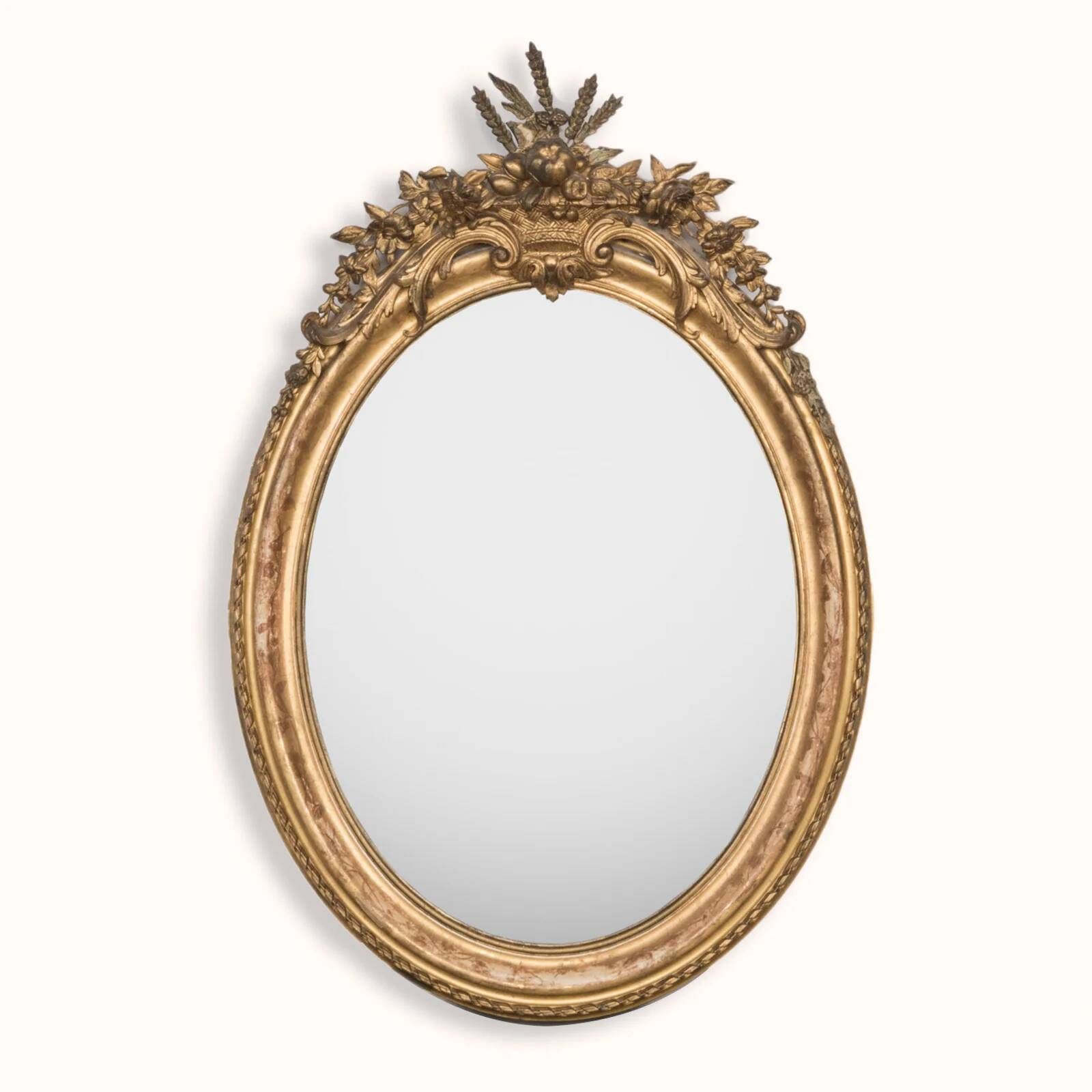 French 19th-century oval mirror in gold leaf with a pediment.