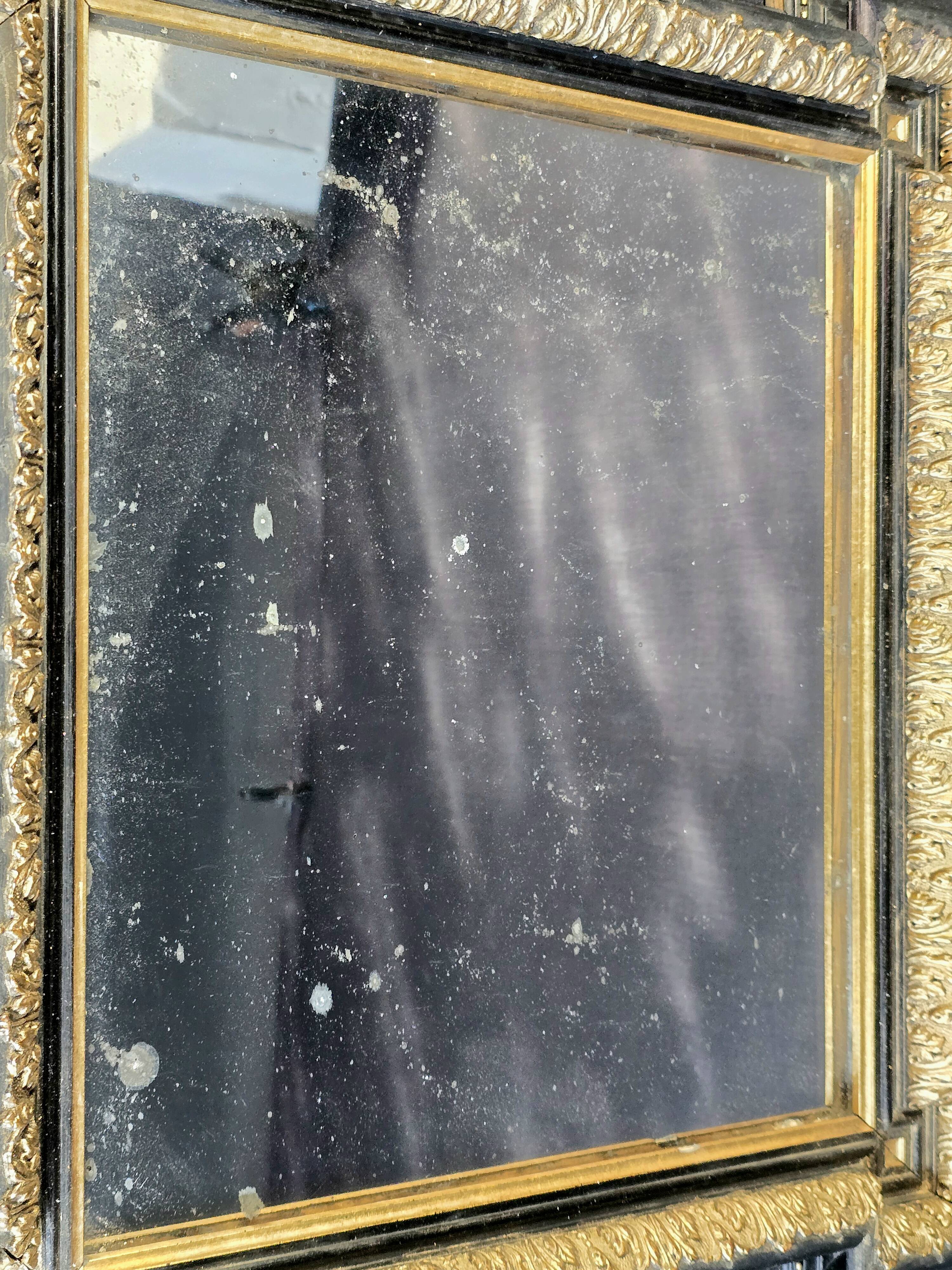 Napoleon III mirror in blackened wood and gilded decoration, second half of the 19th century.