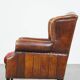 Sheepskin leather wingback chair with a red corduroy seat cushion
