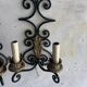 Pair of wall sconces in wrought iron with golden leaf patterns.