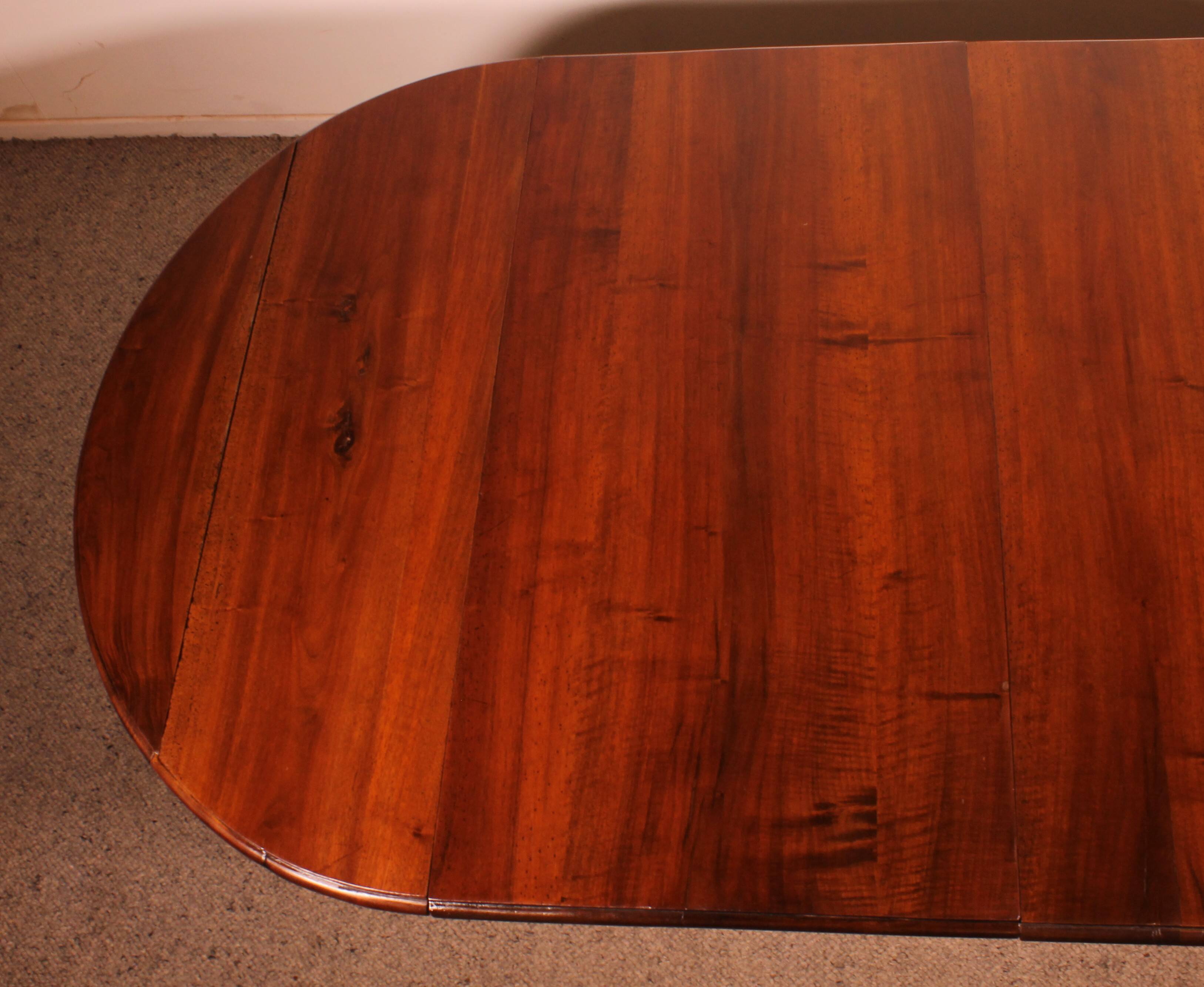 Extensible dining table from the early 19th century in walnut.