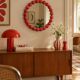Round wall mirror with red beads in vintage retro design style.