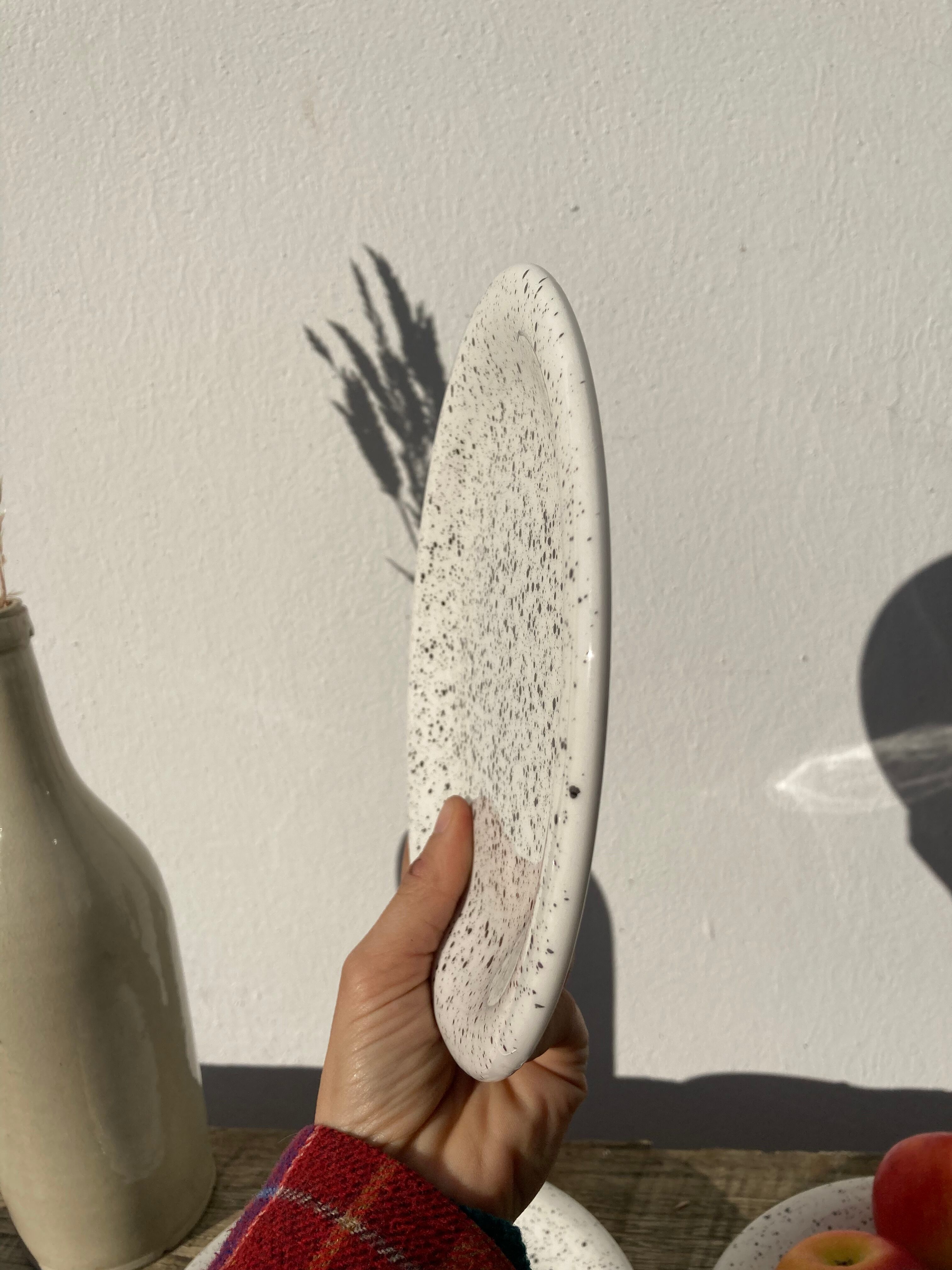 4 black speckled dessert plates on a vintage white background